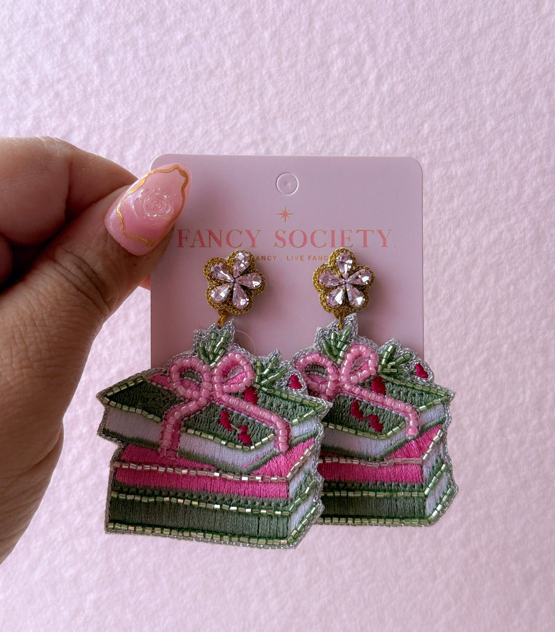 beaded book earrings with a pink bow. 